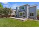 A backyard featuring a well-maintained lawn, a concrete patio, and mature trees, perfect for outdoor entertaining at 14185 W Warren Cir, Lakewood, CO 80228