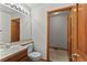 Bathroom with toilet, tile countertop sink, decorative mirror and open door to water closet at 14185 W Warren Cir, Lakewood, CO 80228