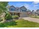 Charming two-story home with brick and siding, a well-manicured lawn, and a two-car garage at 14185 W Warren Cir, Lakewood, CO 80228