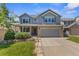 Beautiful two-story home with a well-kept lawn, a two-car garage and decorative stone elements at 14185 W Warren Cir, Lakewood, CO 80228