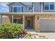 Inviting home featuring a brick facade, covered porch, manicured bushes, and two-car garage at 14185 W Warren Cir, Lakewood, CO 80228