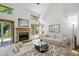 Bright living room with vaulted ceilings, brick fireplace, and access to outdoor space at 14185 W Warren Cir, Lakewood, CO 80228
