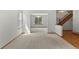 Open-concept living area featuring hardwood floors, plush carpeting, and abundant natural light at 14185 W Warren Cir, Lakewood, CO 80228