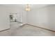 Bright living room with neutral carpet, trim and white walls, connecting to a second room at 14185 W Warren Cir, Lakewood, CO 80228