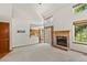 Bright living room with a fireplace and open access to the kitchen, creating a welcoming and connected living space at 14185 W Warren Cir, Lakewood, CO 80228