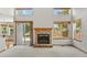 Open living room with fireplace, sliding glass door, and large windows offering plenty of natural light at 14185 W Warren Cir, Lakewood, CO 80228