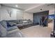 Basement living area with a large gray sofa and workout equipment with gray accent walls at 6581 W Alamo Dr, Littleton, CO 80123