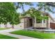 Charming home with a brick archway, a well-maintained lawn, and a welcoming front porch at 6581 W Alamo Dr, Littleton, CO 80123