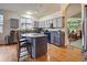 Kitchen with granite counters, gray cabinets, an island with breakfast bar, and stainless appliances at 6581 W Alamo Dr, Littleton, CO 80123