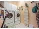 Well-lit laundry room with washer, dryer, utility sink, cabinets, ironing board, and hanging storage at 6581 W Alamo Dr, Littleton, CO 80123