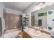 Bathroom with a shower-tub combo, a large mirror, modern lighting, and storage shelves at 9680 Brentwood Way # 202, Broomfield, CO 80021