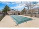 Community pool covered with a safety tarp in a fenced in area surrounded by trees at 9680 Brentwood Way # 202, Broomfield, CO 80021