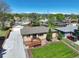 Aerial view of a single-story brick home with a wooden porch, green lawn, detached garage and a long driveway at 3871 Moore St, Wheat Ridge, CO 80033