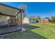 Large backyard with a covered deck, green lawn, and a detached garage at 3871 Moore St, Wheat Ridge, CO 80033
