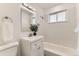 This bathroom features a white vanity, updated fixtures, and a shower-tub combo at 3871 Moore St, Wheat Ridge, CO 80033