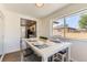 Bright dining area with wood floors, modern table and chairs, and a large window at 3871 Moore St, Wheat Ridge, CO 80033