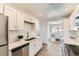 Modern kitchen with white cabinets, stainless steel appliances, and wood-style floors at 3871 Moore St, Wheat Ridge, CO 80033