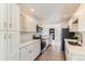 Modern kitchen with white cabinets, stainless steel appliances, quartz countertops, and wood-style floors at 3871 Moore St, Wheat Ridge, CO 80033