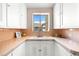 Charming vintage kitchen with a sink, white cabinets, and unique tile countertops under a bright window at 1321 E 10Th Ave # 4, Denver, CO 80218
