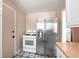 Functional kitchen with stainless steel refrigerator, white appliances, and unique tile flooring at 1321 E 10Th Ave # 4, Denver, CO 80218