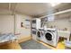 Functional laundry room with multiple washers, dryers, utility sink, and ample storage at 1321 E 10Th Ave # 4, Denver, CO 80218