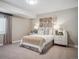 Comfortable bedroom features neutral tones, decorative wall art, side tables with lamps, and a window with curtain at 18940 E 96Th Pl, Commerce City, CO 80022