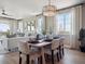 Well-lit dining area with a stylish table setting, view to living room, and large windows at 18940 E 96Th Pl, Commerce City, CO 80022