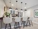 Eat-in kitchen bar area featuring counter seating, pendant lights, stainless steel appliances, and modern finishes at 18940 E 96Th Pl, Commerce City, CO 80022