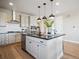 Modern kitchen with stainless appliances, white cabinets, and an island with seating at 18940 E 96Th Pl, Commerce City, CO 80022