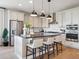 Stylish kitchen with stainless appliances, white cabinets, an island and hardwood floors at 18940 E 96Th Pl, Commerce City, CO 80022