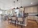 Bright, open kitchen featuring a center island, stainless steel appliances, and modern pendant lighting at 18940 E 96Th Pl, Commerce City, CO 80022