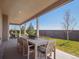 Covered patio with an outdoor dining table and chairs overlooking a well-maintained lawn at 18940 E 96Th Pl, Commerce City, CO 80022
