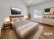 Staged main bedroom featuring a ceiling fan, natural light, and neutral tones at 5966 S Winnipeg St, Aurora, CO 80015