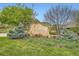Entrance to Rolling Hills featuring stone signage, landscaping, and mature trees at 15325 W 32Nd Ave, Golden, CO 80401