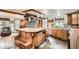Open kitchen with stone accent wall, oversized island, bar seating, wood cabinets, and unique backsplash at 15325 W 32Nd Ave, Golden, CO 80401
