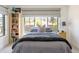 Bright bedroom featuring a large window, stylish bedding and a bookcase at 5455 E Cedar Ave, Denver, CO 80246
