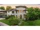 Stunning stone-clad home boasts mature trees, lush lawn, and meticulous landscaping at 5455 E Cedar Ave, Denver, CO 80246