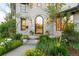 Charming front entrance with stone accents, arched door, and vibrant flower beds at 5455 E Cedar Ave, Denver, CO 80246