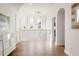 Spacious hallway with hardwood floors, arched doorways, modern lighting, and white trim at 5455 E Cedar Ave, Denver, CO 80246