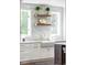 Bright kitchen featuring white cabinets, open wood shelving, and white subway tile backsplash at 5455 E Cedar Ave, Denver, CO 80246