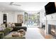 Open living room with fireplace and view of backyard pool area through French doors at 5455 E Cedar Ave, Denver, CO 80246