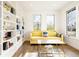 Cozy living room featuring a yellow sofa, a glass coffee table, and built-in bookshelves at 5455 E Cedar Ave, Denver, CO 80246