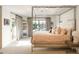 Stylish main bedroom featuring a striking bed frame, a view through french doors and large windows at 5455 E Cedar Ave, Denver, CO 80246
