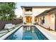Backyard pool with modern patio and seating, surrounded by lush landscaping and a well-maintained exterior at 5455 E Cedar Ave, Denver, CO 80246