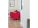 Sitting area with hot pink chairs, gold legs and light hardwood flooring at 5455 E Cedar Ave, Denver, CO 80246