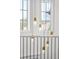 Modern pendant lights hang above the staircase with wrought iron railing at 5455 E Cedar Ave, Denver, CO 80246
