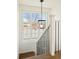 Bright staircase landing with modern light fixture, large window, and black wrought iron balusters at 5455 E Cedar Ave, Denver, CO 80246