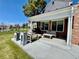 Covered porch with brick, outdoor seating, and a built-in grill overlooking the yard at 7079 S Locust Pl, Centennial, CO 80112