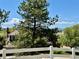 View of a beautiful yard with fencing, trees, a house, and the mountains in the distance at 7079 S Locust Pl, Centennial, CO 80112