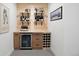 Chic basement bar features wooden shelving, custom cabinets, and under-counter beverage refrigerator at 7079 S Locust Pl, Centennial, CO 80112